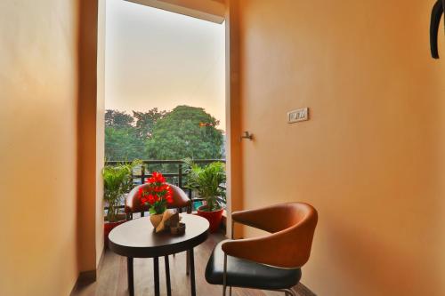 a room with a table and chairs and a balcony at Gulmohar inn in Lucknow