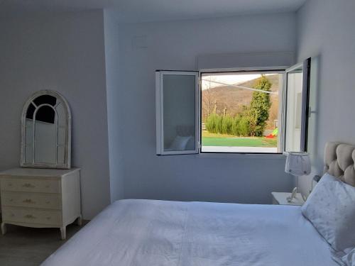 um quarto com uma cama branca e uma janela em Villa de lujo en Jarandilla em Jarandilla de la Vera