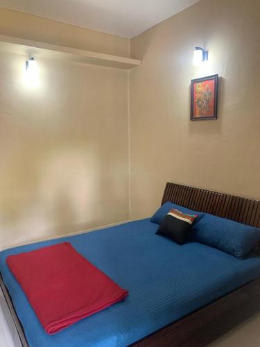 a bedroom with a blue bed with two pillows at RD's abode in Kozhikode