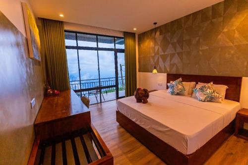 a bedroom with a large bed and a large window at leisure Mount View in Haputale
