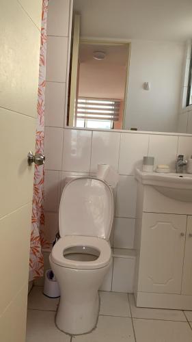 a bathroom with a white toilet and a sink at Depto. Edificio Miramar 2D 2B cerca de Playa Cavancha in Iquique