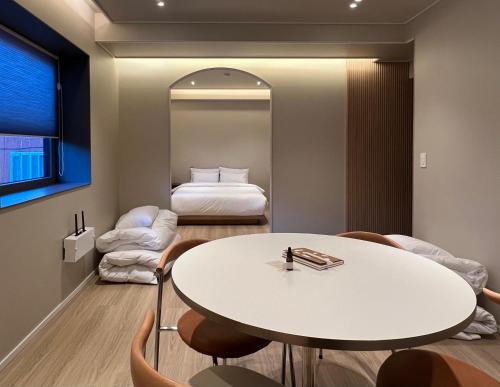 Cette chambre comprend une table, un lit et un miroir. dans l'établissement Stay Dooroo, à Suncheon