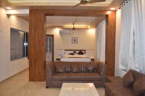 un salon avec un canapé et un lit dans l'établissement SEA LUXE Beach Resort, à Dapoli