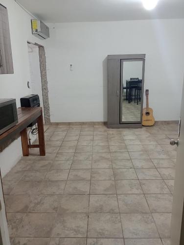 Habitación con suelo de baldosa, mesa y espejo. en Apartamento Puente del Zorro, en Ciudad Juárez