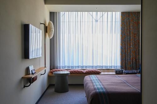 a hotel room with a bed and a window at Ace Hotel Kyoto in Kyoto