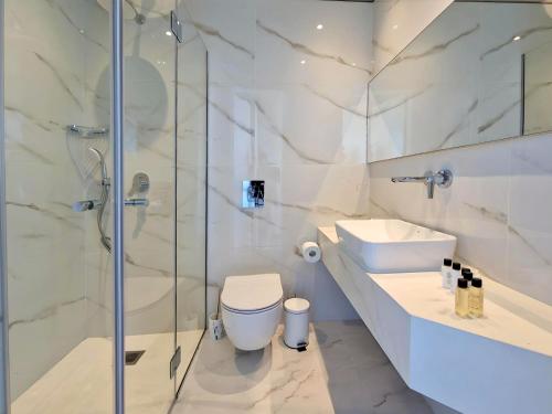 a bathroom with a shower and a toilet and a sink at Aeon Residences - In the heart of Paphos in Paphos City