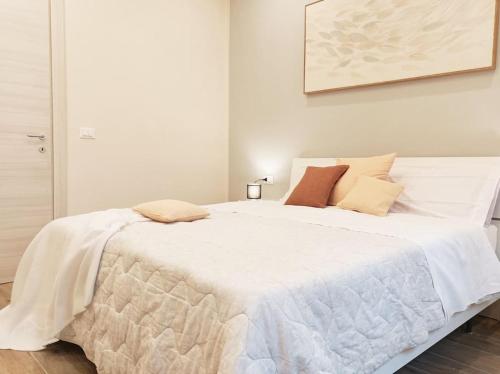 QuickHome Appartamento Edera في بييلا: سرير ابيض عليه مخدات في غرفه