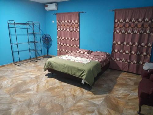 1 dormitorio con cama y pared azul en Bijilo Villa, en Bijilo
