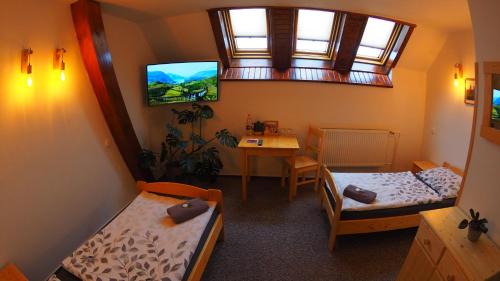 una camera con due letti e un tavolo e una finestra di HOTEL BRITANNIA VSETÍN a Vsetín