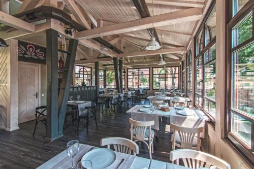 a dining room with tables and chairs and windows at Villa Mozart in Truskavets