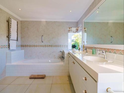 bagno con 2 lavandini, vasca e doccia di Joie De Vivre - 22 Rocklands a Hermanus