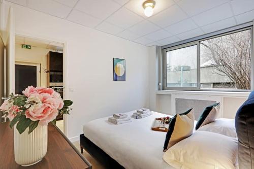 Cette chambre comprend un lit avec un vase de fleurs. dans l'établissement Beautiful apartment 4P/1BR Champs Elysées, à Paris