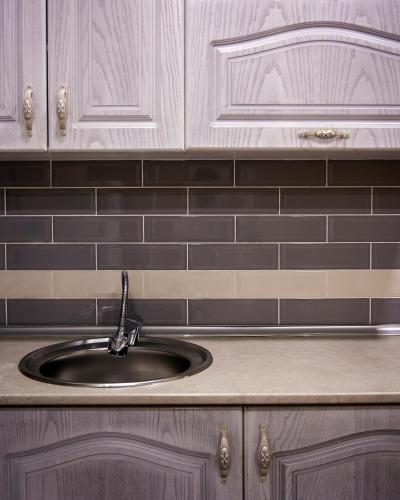 a kitchen counter with a sink and black tiles at Dream Inn H&A in Tashkent