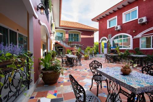 an outdoor patio with tables and chairs and plants at Hacienda Resort - Mae Phim in Mae Pim