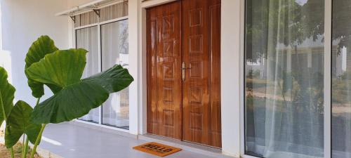 a front door of a house with a plant next to it at Cave Diani Holiday Apartments in Diani Beach