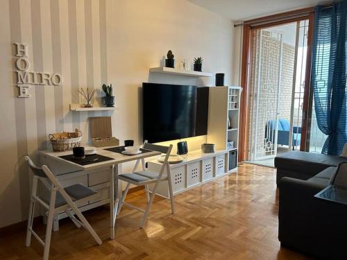 ein Wohnzimmer mit einem Tisch mit Stühlen und einem TV in der Unterkunft Appartamento raffinato su Roma zona Aurelia in Rom