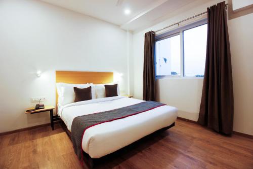 um quarto com uma cama grande e uma janela em Townhouse RCC Elite em Ameerpet