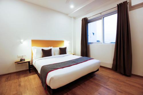 a bedroom with a large bed and a window at Townhouse RCC Elite in Ameerpet