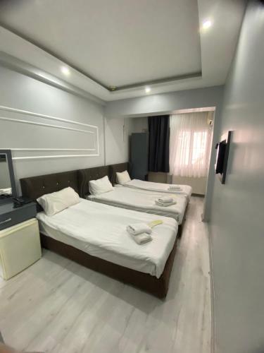a bedroom with two beds and a flat screen tv at Abam Hotel in Istanbul