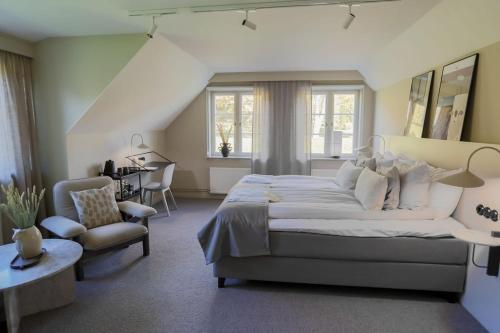 ein großes Schlafzimmer mit einem großen Bett und einem Stuhl in der Unterkunft Margretetorps Gästgifvaregård in Vejbystrand