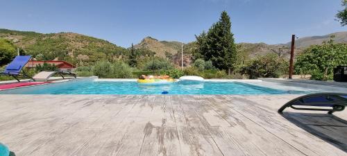 a pool with two people in a raft in the water at Rincón de Elena in Quéntar