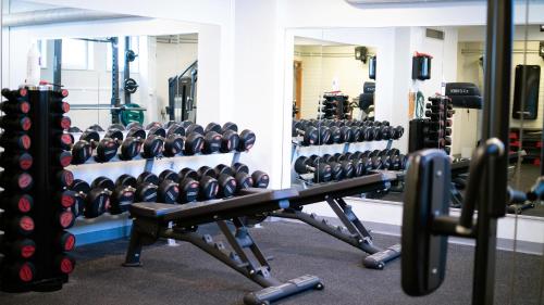 a gym with several rows of dumbbells and mirrors at Medlefors Hotell & Konferens in Skellefteå