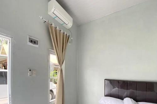 a bedroom with a bed and a ceiling fan at RedDoorz Syariah near Kantor Bupati Pantai Pandan Sibolga in Halangan