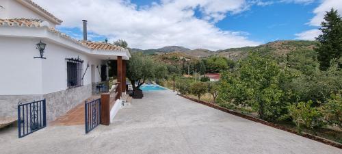 a driveway leading to a house with a pool at Rincón de Elena in Quéntar