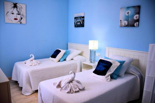Habitación azul con 2 camas y toallas. en Villa Playa Blanca, en Playa Blanca