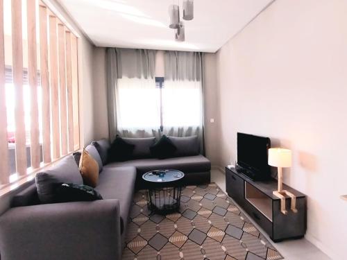 a living room with a couch and a tv at Beautiful apartment next to airport Mohamed V in Derroua