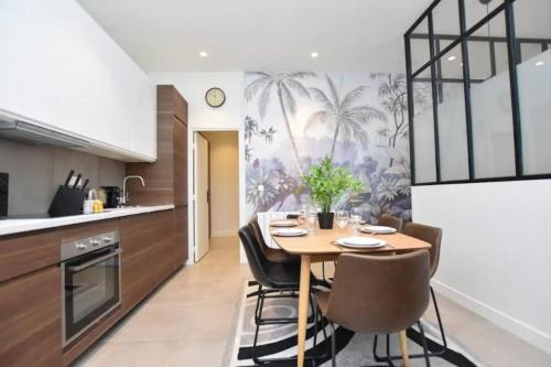 une salle à manger avec une table et des chaises dans une cuisine dans l'établissement Charming Apartment -3BR/6P-Gare du Nord/Montmartre, à Paris