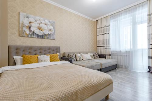 1 dormitorio con 1 cama y 1 sofá en Просторная квартира в Expo Boulevard, en Astana