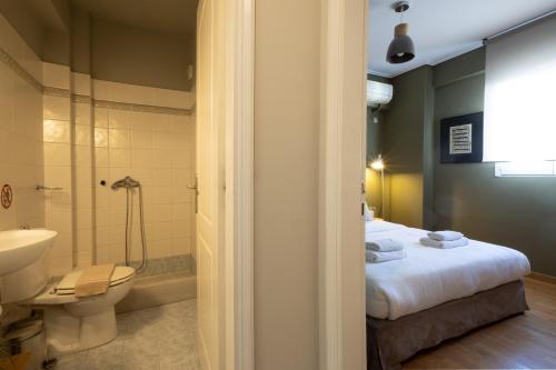 アテネにあるRenovated 3 bedroom apt with Acropolis Viewのバスルーム(ベッド1台、シャワー、トイレ付)