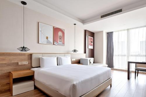a hotel room with a bed and a desk at MontClassic Hotel Chongqing in Chongqing