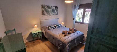 a bedroom with a bed with a teddy bear on it at Rincón de Elena in Quéntar