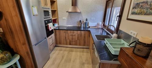 a kitchen with a stainless steel refrigerator and a sink at Rincón de Elena in Quéntar