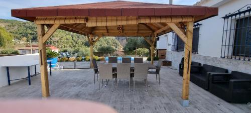 a wooden pavilion with chairs and tables on a patio at Rincón de Elena in Quéntar