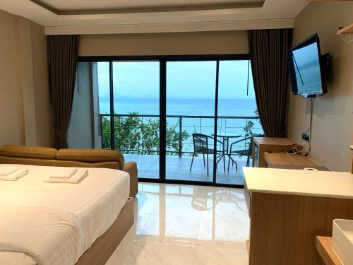 a hotel room with a bed and a view of the ocean at HEAVEN HILL LANTA in Ko Lanta