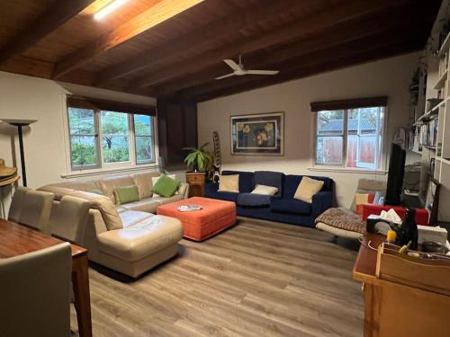a living room with a couch and a table at Cosy two bedroom bungalow close to lake and ocean in Berrara