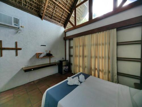 a bedroom with a bed in a room with a window at Alta Vista Ilocandia Inc. in Pagudpud