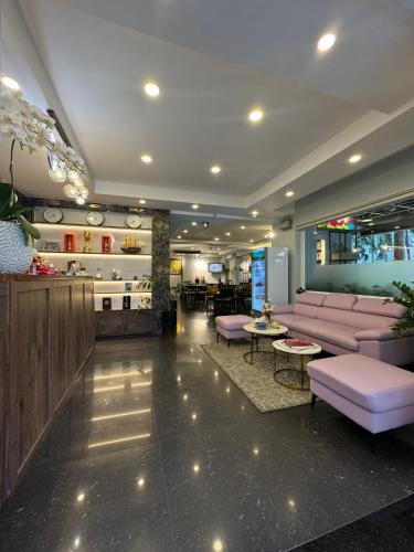 a lobby with pink couches and a bar at Paragon Hotel PMH in Ho Chi Minh City