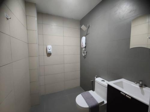 a white bathroom with a toilet and a sink at Hotel Ching Hua in Segamat