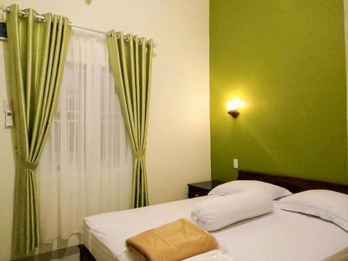 Un dormitorio con una cama con paredes verdes y una ventana en RedDoorz near Pantai Pandan Sibolga 2 en Halangan