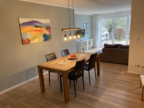 a dining room with a wooden table and chairs at Landhaus Böhmer, Ferienwohnung Gohrisch in Papstdorf