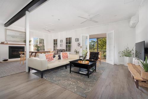 a living room with a couch and a table at Myrtle Tree Lodge Flowers - heart of the village in Kangaroo Valley