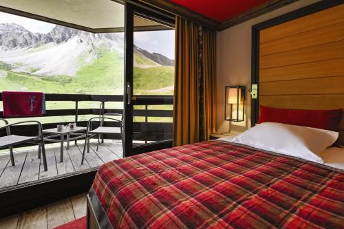 a bedroom with a bed and a balcony with a view at Belambra Clubs Tignes Val Claret in Tignes