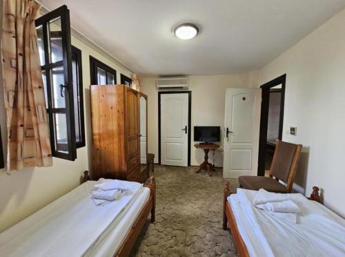 下巴尼亞的住宿－Вилна Къща Кедър，一间带两张床和椅子的房间