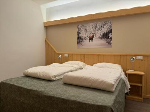 1 dormitorio con 1 cama con una foto en la pared en Life Hotels Des Alpes, en Folgaria