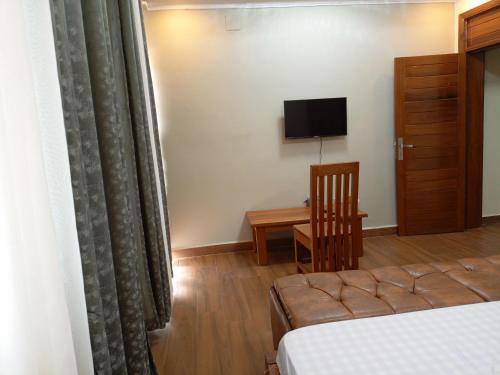 um quarto de hotel com uma cama e uma televisão em Kigali Nice Apartment em Kigali