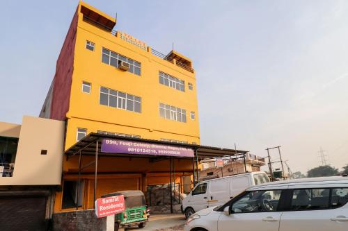 a yellow building with cars parked in front of it at OYO Samrat Residency in Faridabad